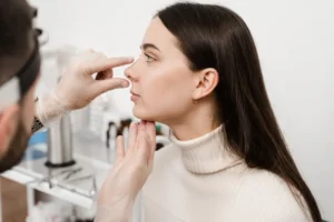 doctor examining a womans nose profile