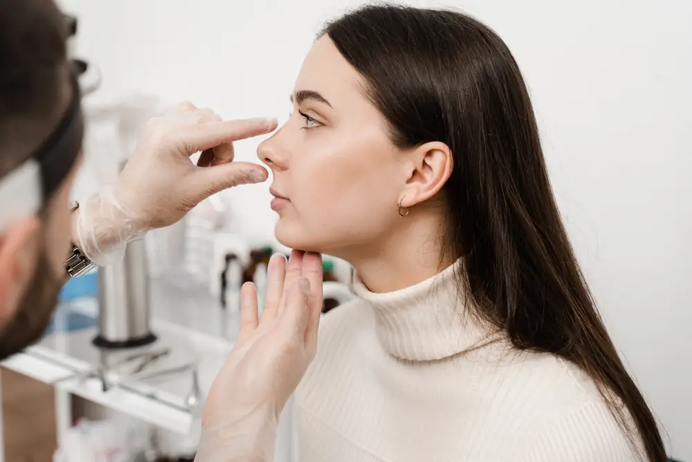 doctor examining a womans nose profile